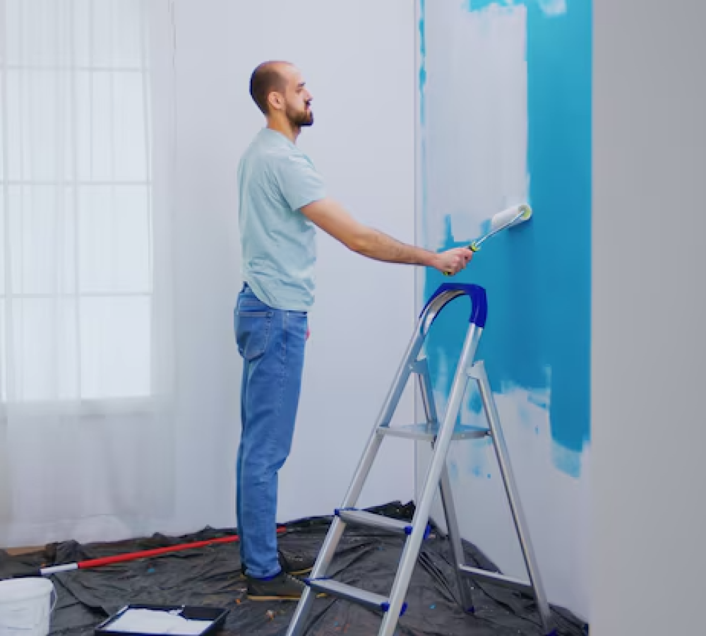 handyman-painting-wall-with-roller-brush-dipped-white-paint-handyman-renovating-apartment-redecoration-home-construction-while-renovati